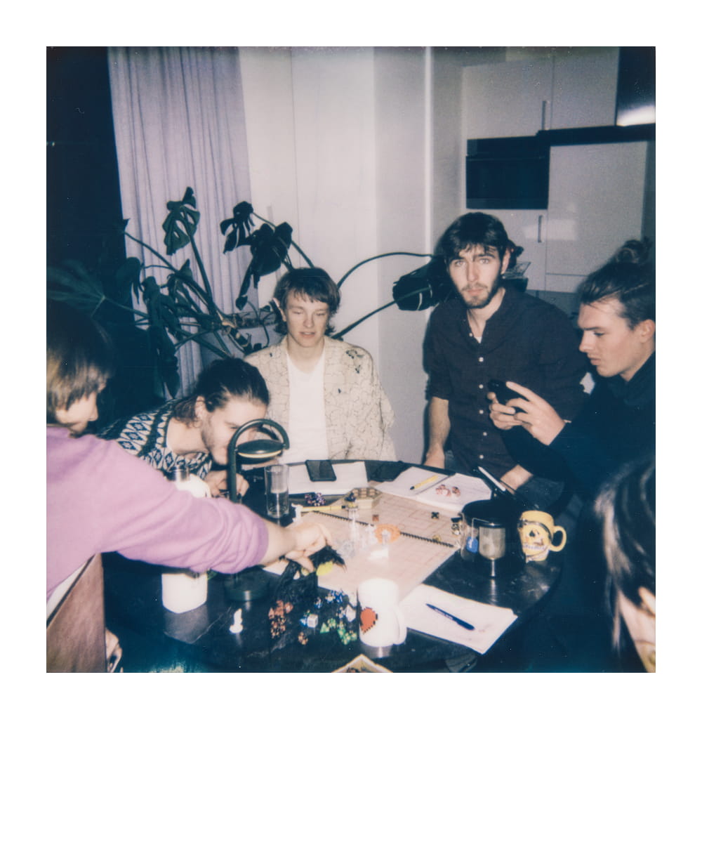 Jogadores reunidos em uma mesa de Dungeons & Dragons com dados, miniaturas e cadernos
