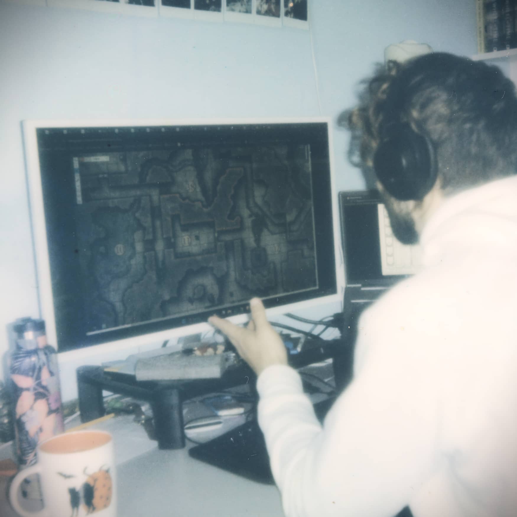 Mestre de Jogo revisando um mapa de masmorras de fantasia sombria na tela enquanto se prepara para uma sessão de D&D